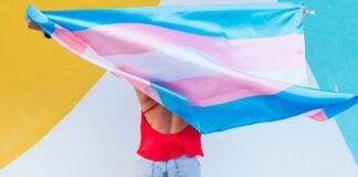 Alerta en Tennessee: Ley obligaría a crear un “registro trans” A person holding a trans flag.